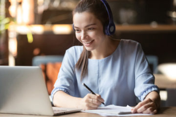 women at computer learning with headphones on